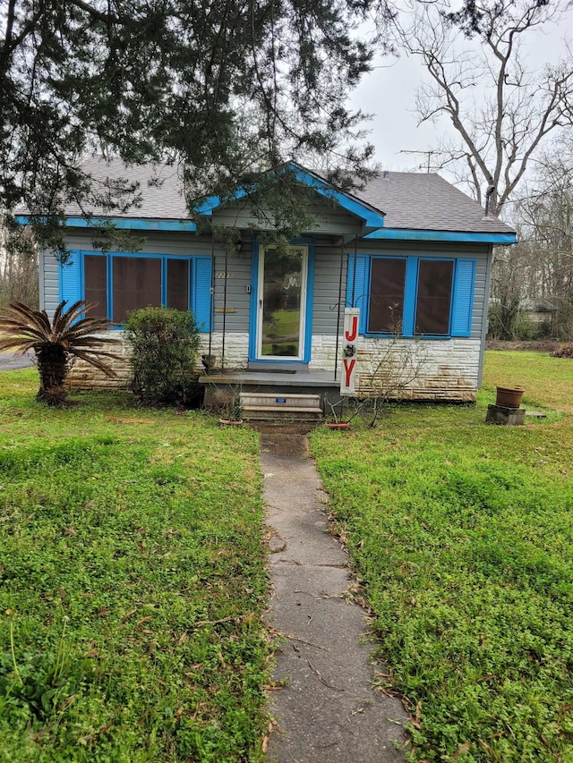 view of front of house featuring stone siding and a front yard