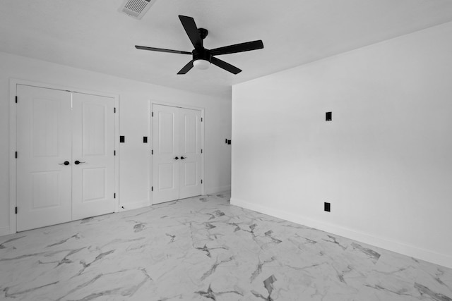 2319 Helena Ave, Nederland, TX 77627 - unfurnished bedroom featuring two closets, baseboards, marble finish floors, and a ceiling fan