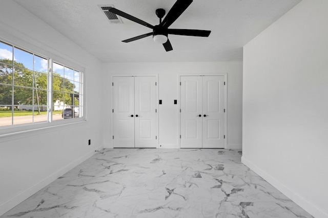 2319 Helena Ave, Nederland, TX 77627 - unfurnished bedroom featuring multiple closets, baseboards, light marble finish floors, and ceiling fan