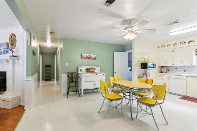 dining area with ceiling fan and a textured ceiling