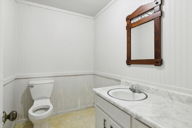 bathroom featuring vanity, toilet, and ornamental molding