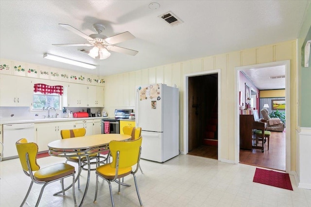 kitchen with white appliances, sink, ceiling fan, a textured ceiling, and white cabinetry