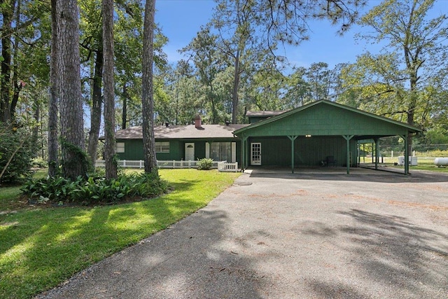 ranch-style home featuring a carport and a front yard