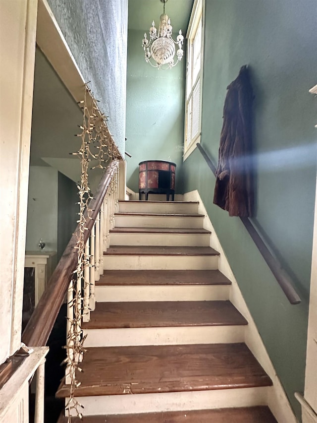 stairs with a notable chandelier