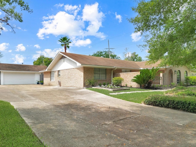 single story home with driveway, a garage, and brick siding