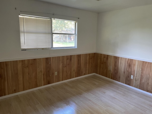 spare room with wooden walls and light hardwood / wood-style flooring