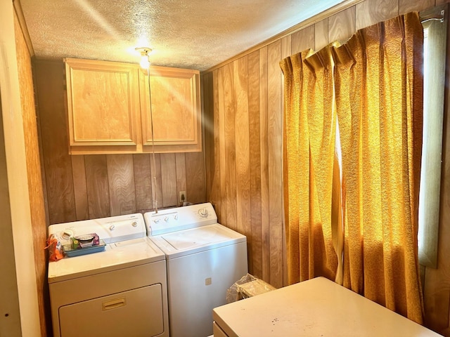 4350 Dallas Ave, Beaumont, TX 77703 - washroom with washing machine and clothes dryer, cabinet space, a textured ceiling, and wood walls