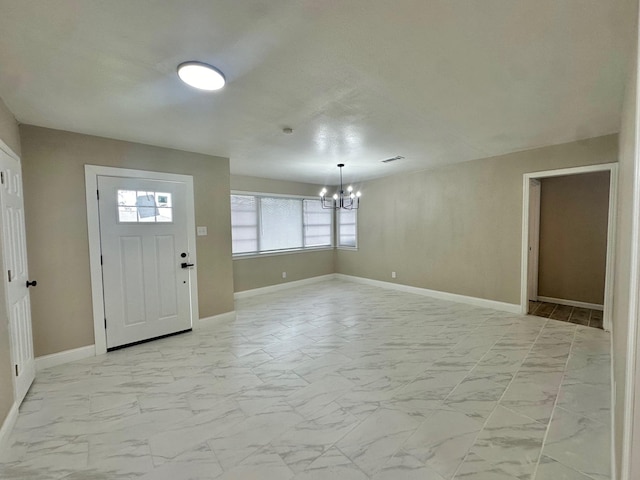 foyer entrance with a chandelier