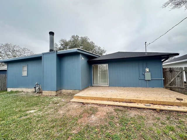 back of house with a wooden deck and a yard