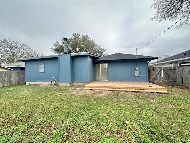 back of house featuring a wooden deck and a yard