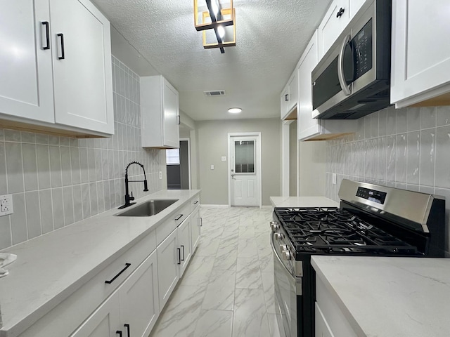 kitchen featuring white cabinetry, stainless steel appliances, sink, and light stone counters