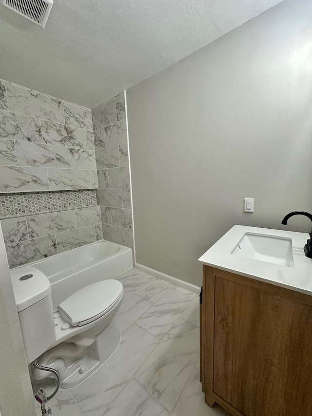 full bathroom featuring vanity, tiled shower / bath combo, toilet, and a textured ceiling