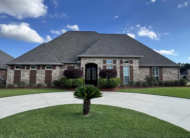 156 Remington Cir, Lumberton, TX 77657 - french country inspired facade featuring a front yard, brick siding, and roof with shingles