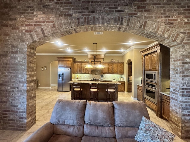 156 Remington Cir, Lumberton, TX 77657 - kitchen with appliances with stainless steel finishes, open floor plan, ornamental molding, arched walkways, and light tile patterned flooring