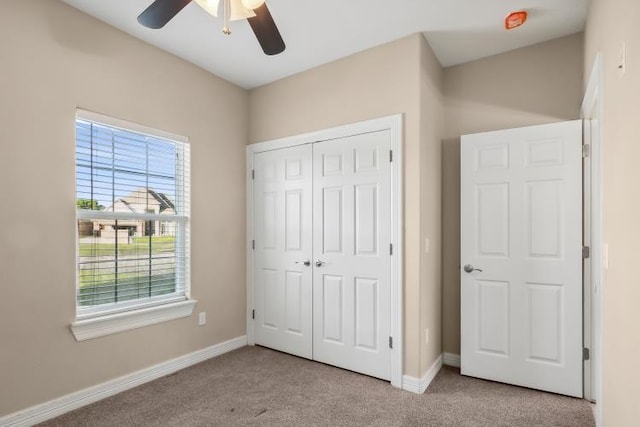 unfurnished bedroom with light carpet, a closet, and ceiling fan