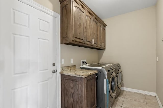 washroom featuring cabinets, separate washer and dryer, and light tile patterned floors