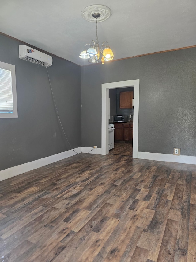 936 9th St, Port Arthur, TX 77640 - spare room with an AC wall unit, dark wood-type flooring, and a chandelier
