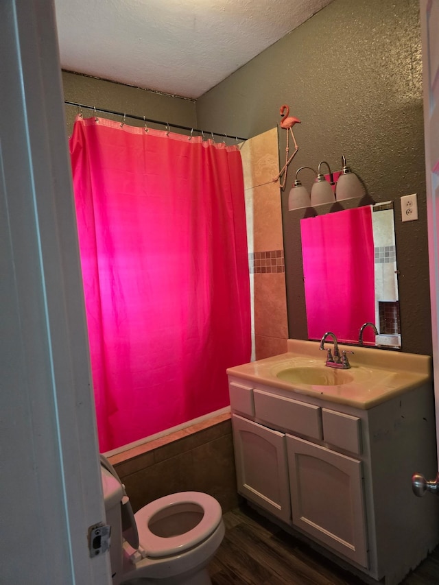 936 9th St, Port Arthur, TX 77640 - bathroom with vanity, wood finished floors, a textured ceiling, curtained shower, and a textured wall