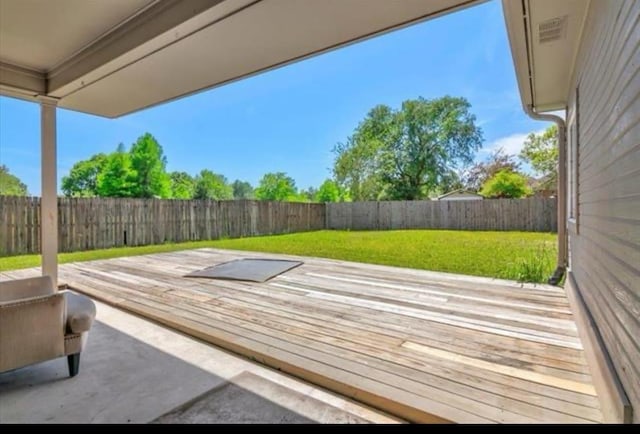 wooden deck featuring a yard, a patio, and a fenced backyard