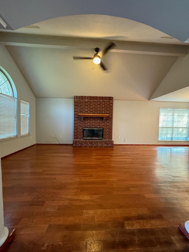 unfurnished living room featuring hardwood / wood-style floors, lofted ceiling with beams, ceiling fan, and a fireplace