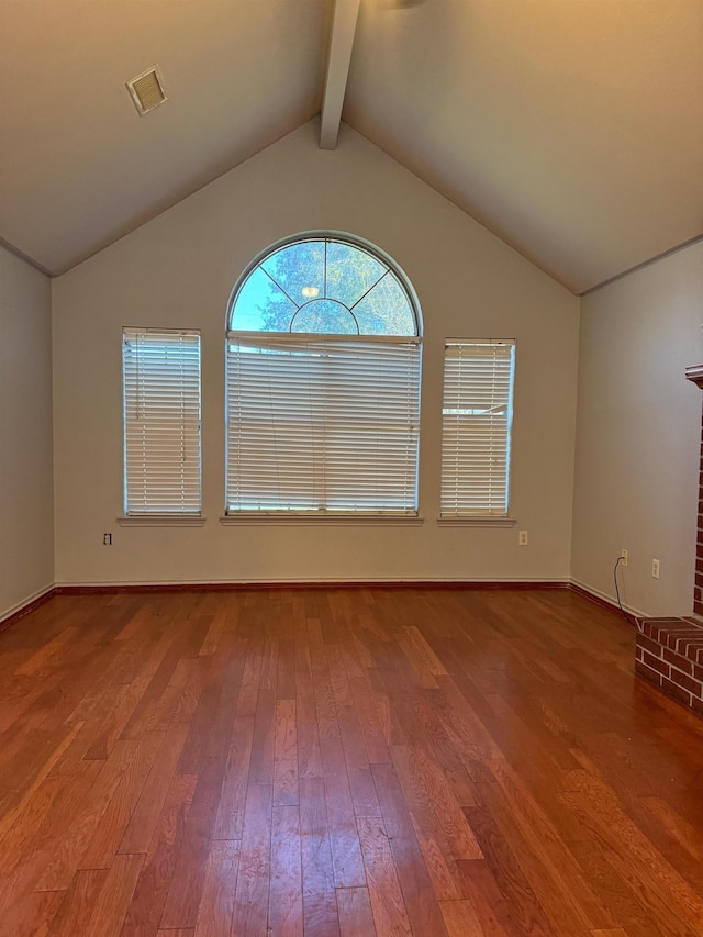 unfurnished room with hardwood / wood-style floors and lofted ceiling with beams