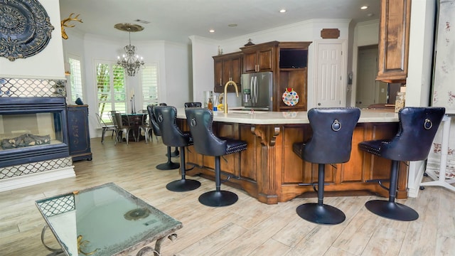 5065 Turner Rd, Orange, TX 77630 - kitchen with stainless steel refrigerator with ice dispenser, a chandelier, light wood-style flooring, ornamental molding, and light countertops