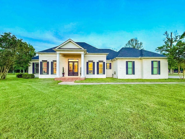 5065 Turner Rd, Orange, TX 77630 - neoclassical home featuring french doors, a front yard, and a shingled roof