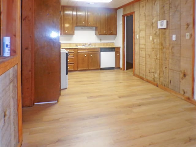 kitchen featuring light wood-type flooring, dishwasher, light countertops, and a sink