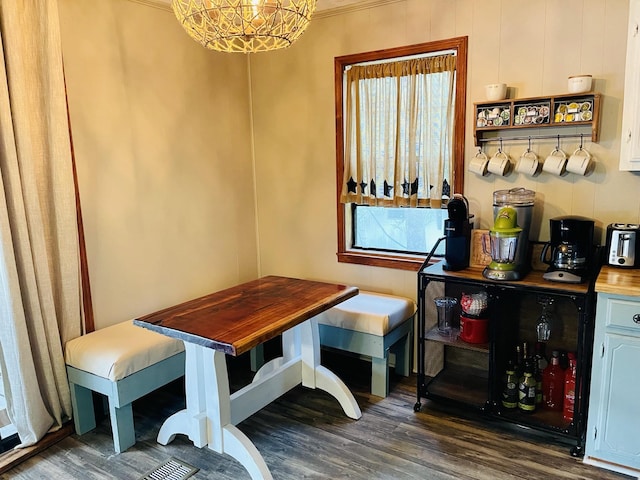 dining area featuring a healthy amount of sunlight, dark hardwood / wood-style flooring, an inviting chandelier, and crown molding