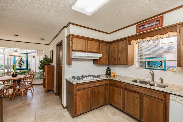 kitchen featuring tasteful backsplash, sink, white appliances, hanging light fixtures, and a textured ceiling