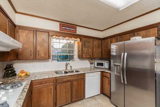 kitchen featuring sink, white appliances, a textured ceiling, and tasteful backsplash