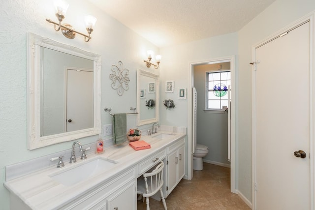 bathroom featuring a textured ceiling, toilet, and vanity