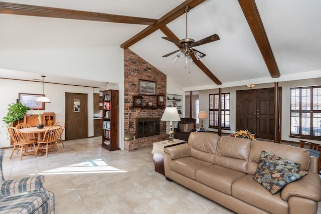 tiled living room with ceiling fan, beam ceiling, a brick fireplace, and high vaulted ceiling