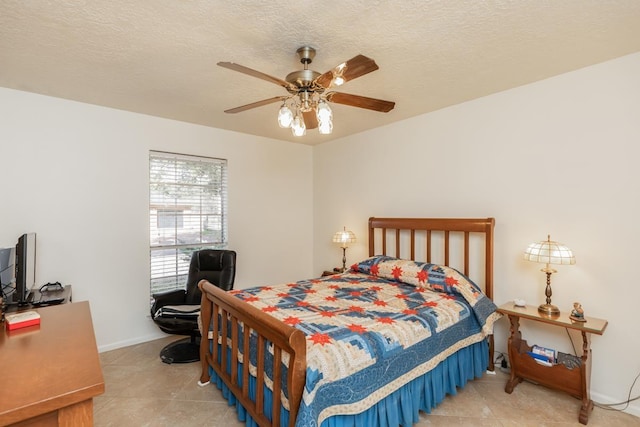 bedroom with ceiling fan and a textured ceiling