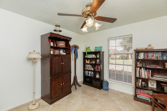 miscellaneous room featuring ceiling fan, a textured ceiling, and light tile patterned floors