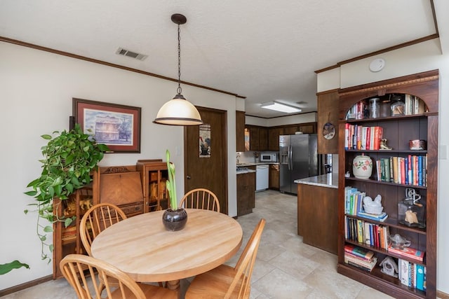 dining space featuring a textured ceiling and ornamental molding