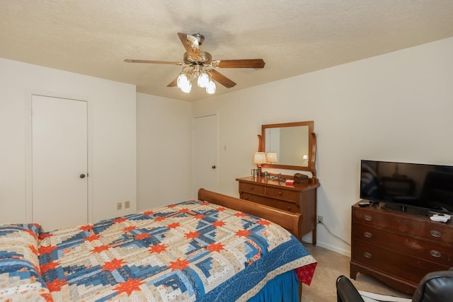 carpeted bedroom featuring a textured ceiling and ceiling fan