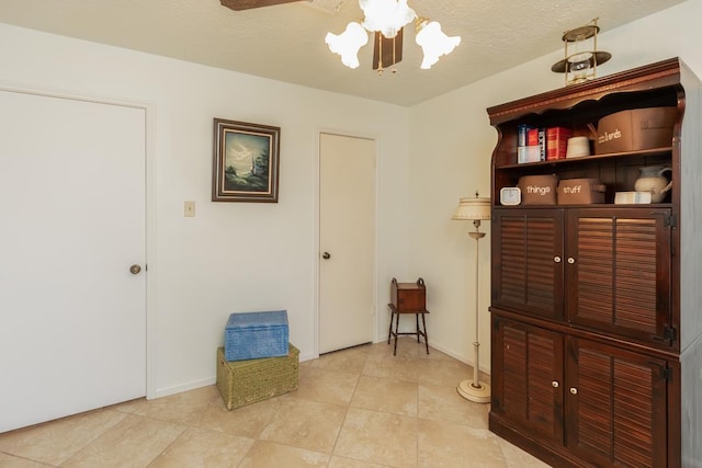 misc room with ceiling fan and a textured ceiling