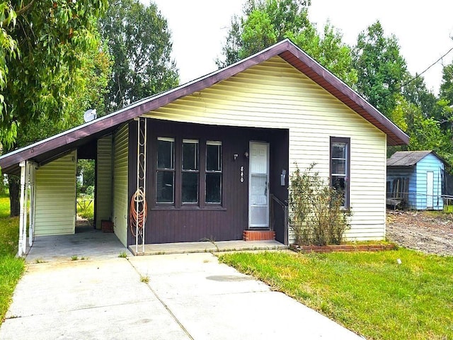 view of front of property featuring a front yard and a carport