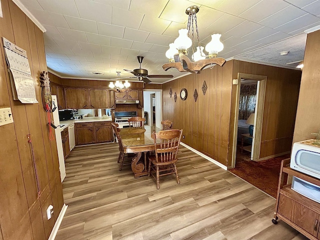 2349 Amino St, Port Arthur, TX 77640 - dining room featuring a chandelier, light wood-style floors, wooden walls, and ornamental molding