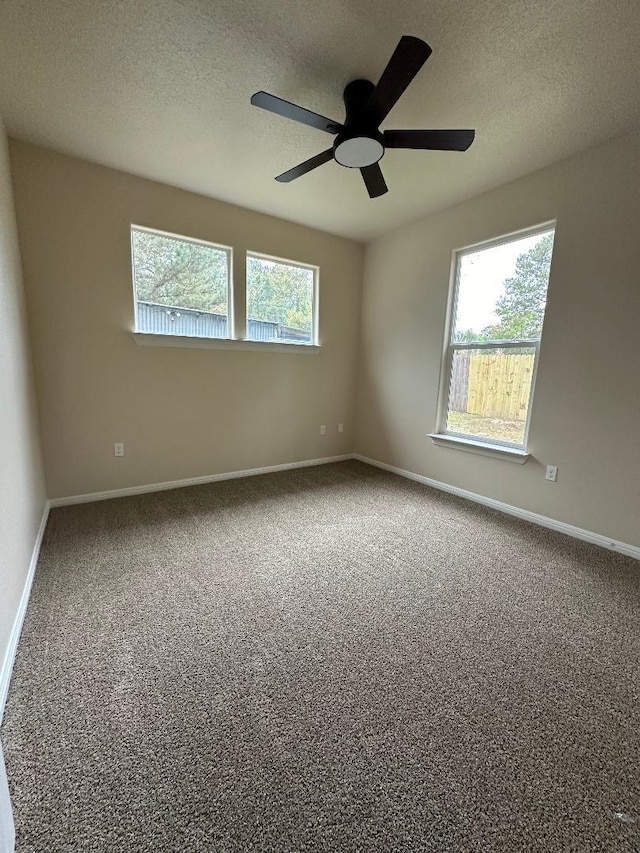 carpeted spare room featuring a textured ceiling and ceiling fan