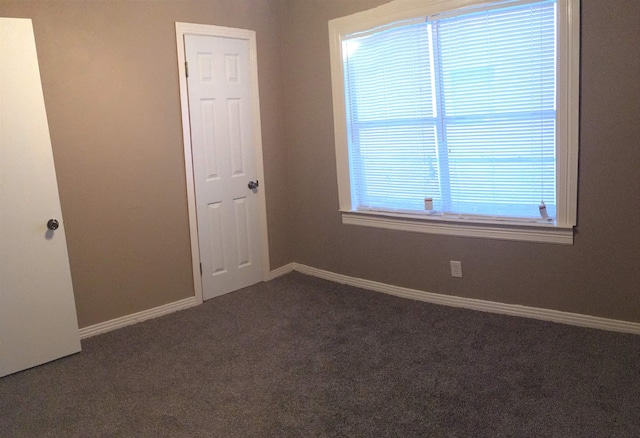 2333 1st St, Port Neches, TX 77651 - empty room featuring dark colored carpet and baseboards