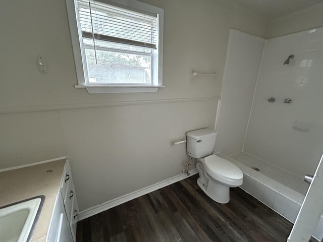 full bathroom with baseboards, a shower, toilet, wood finished floors, and vanity