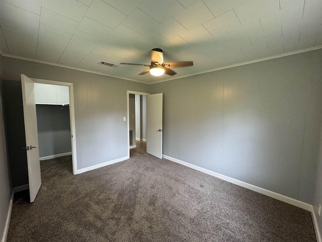 unfurnished bedroom featuring dark colored carpet, ceiling fan, and ornamental molding