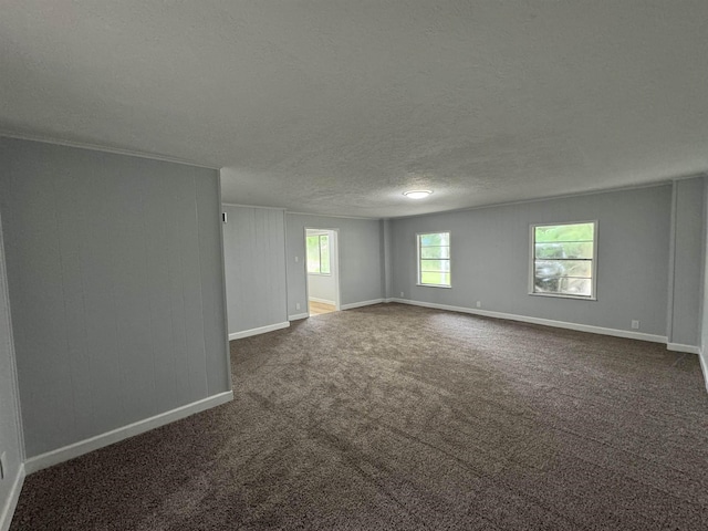 empty room with a textured ceiling and dark carpet