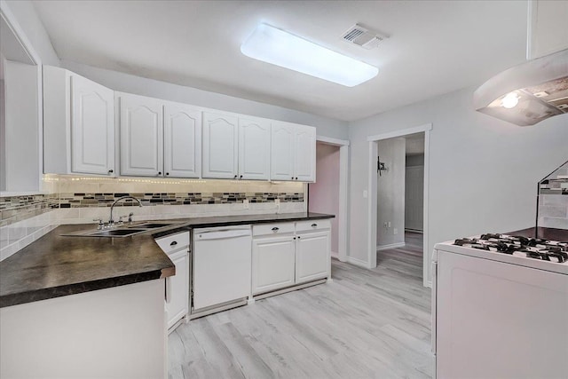 2125 10th St, Port Neches, TX 77651 - kitchen featuring white appliances, dark countertops, a sink, decorative backsplash, and white cabinets