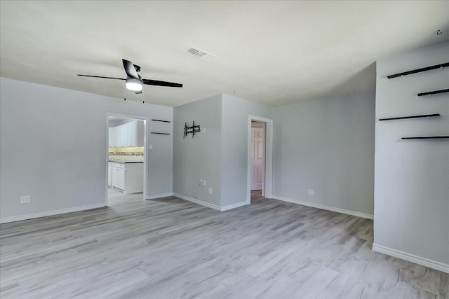 2125 10th St, Port Neches, TX 77651 - empty room with light wood-style flooring, a ceiling fan, and baseboards