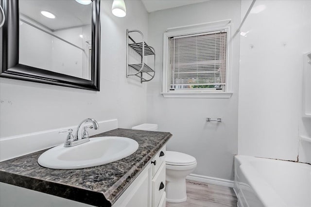 2125 10th St, Port Neches, TX 77651 - bathroom featuring vanity, toilet, baseboards, and wood finished floors