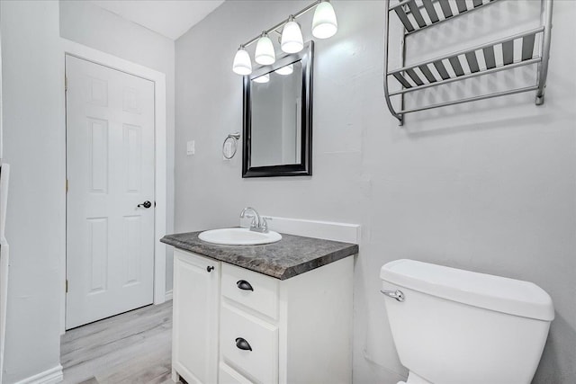 2125 10th St, Port Neches, TX 77651 - bathroom featuring wood finished floors, vanity, and toilet