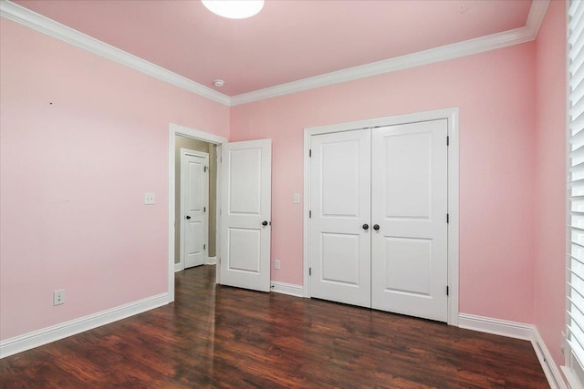 unfurnished bedroom with a closet, crown molding, and dark hardwood / wood-style flooring